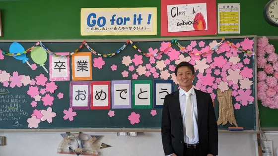 教師時代の早川滉貴。教室にて卒業式の装飾を背景に